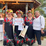 Laureaci I miejsca : Koło Gospodyń Wiejskich Twórcza Osada w Biedaszce pozują do zdjęcia wraz z przedstawicielem komisji konkursowej podczas I etapu konkursu Bitwa Regionów w Bagnie