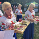 Przedstawicielki jednego z Kół Gospodyń Wiejskich w trakcie przenoszenia  tacy z potrawą do prezentacji przed komisją konkursową podczas I etapu konkursu Bitwa Regionów w Książu