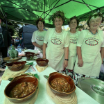 Przedstawicielki Koła Gospodyń Wiejskich  Lutomia Dolna w trakcie prezentacji potrawy "gulasz myśliwski z chlebkiem Izy" przed komisją konkursową podczas I etapu konkursu Bitwa Regionów w Książu
