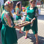 Przedstawicielki jednego z Kół Gospodyń Wiejskich w trakcie przenoszenia  dużej tacy z potrawą do prezentacji przed jury podczas I etapu konkursu Bitwa Regionów w Siechnicach