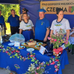 Przedstawiciele Koła Gospodyń Wiejskich Czerna pozujący do zdjęcia na swoim stoisku.