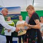 Dyrektor OT KOWR na scenie wręcza nagrodę uczestniczce w konkursie wojewódzkim Bitwa Regionów we Wrocławiu.