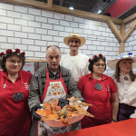 Przewodniczący wraz z przedstawicielami zwycięskiego Koła Gospodyń Wiejskich  Zakocie „Wygodni Zakociacy” pozujący do zdjęcia z potrawa: Raki po polsku – derte koty na targach Grüne Woche w Belinie.