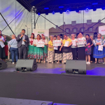 Grupa kobiet pozuje wspólnie na scenie do pamiątkowego zdjęcia