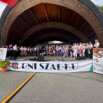 Grupa osób pozuje wspólnie na scenie do pamiątkowego zdjęcia