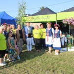 Laureaci II miejsca - przedstawicielki Koła Gospodyń Wiejskich Mysłowianki w Mysłowie podczas pozowania do zdjęcia wspólnie z organizatorami wydarzenia  przed swoim stoiskiem podczas I Etapu konkursu kulinarnego Bitwa Regionów w Szycach