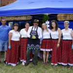 Członkowie Koła Gospodyń Wiejskich Wierzbowianki w czerwonych spódnicach i ludowym fartuchu prezentują stoisko na Bitwie Regionów w Nidzicy